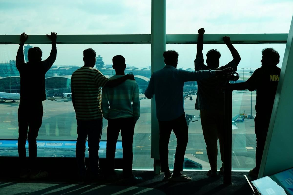 Friends looking out of an airport window at the planes