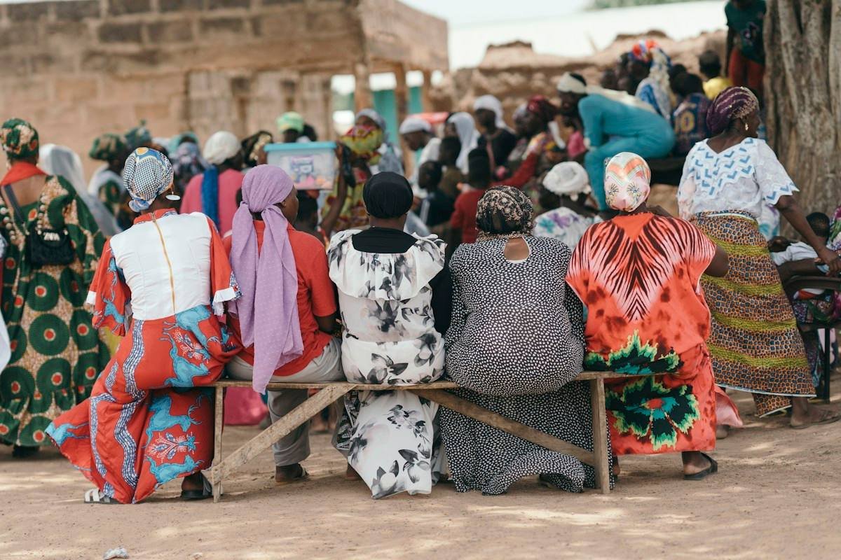 Women gathered in conversation on a bench in West Africa
