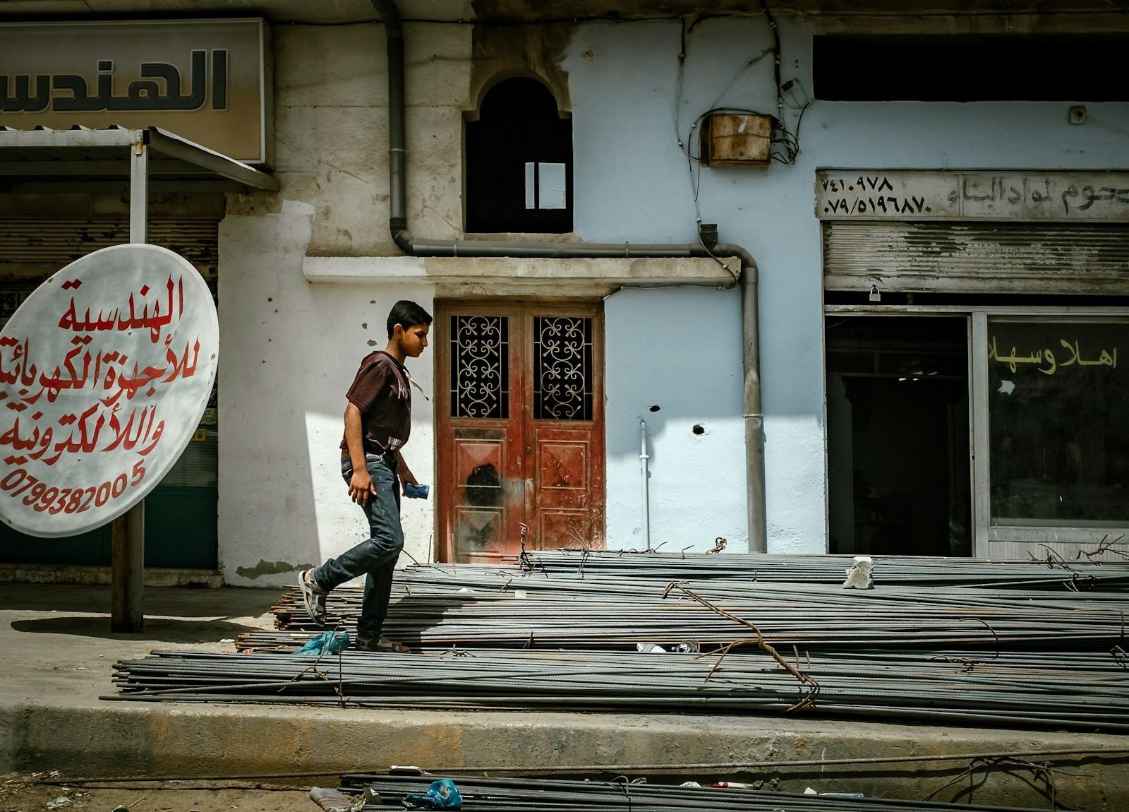 A young man walking down a street in Jordan