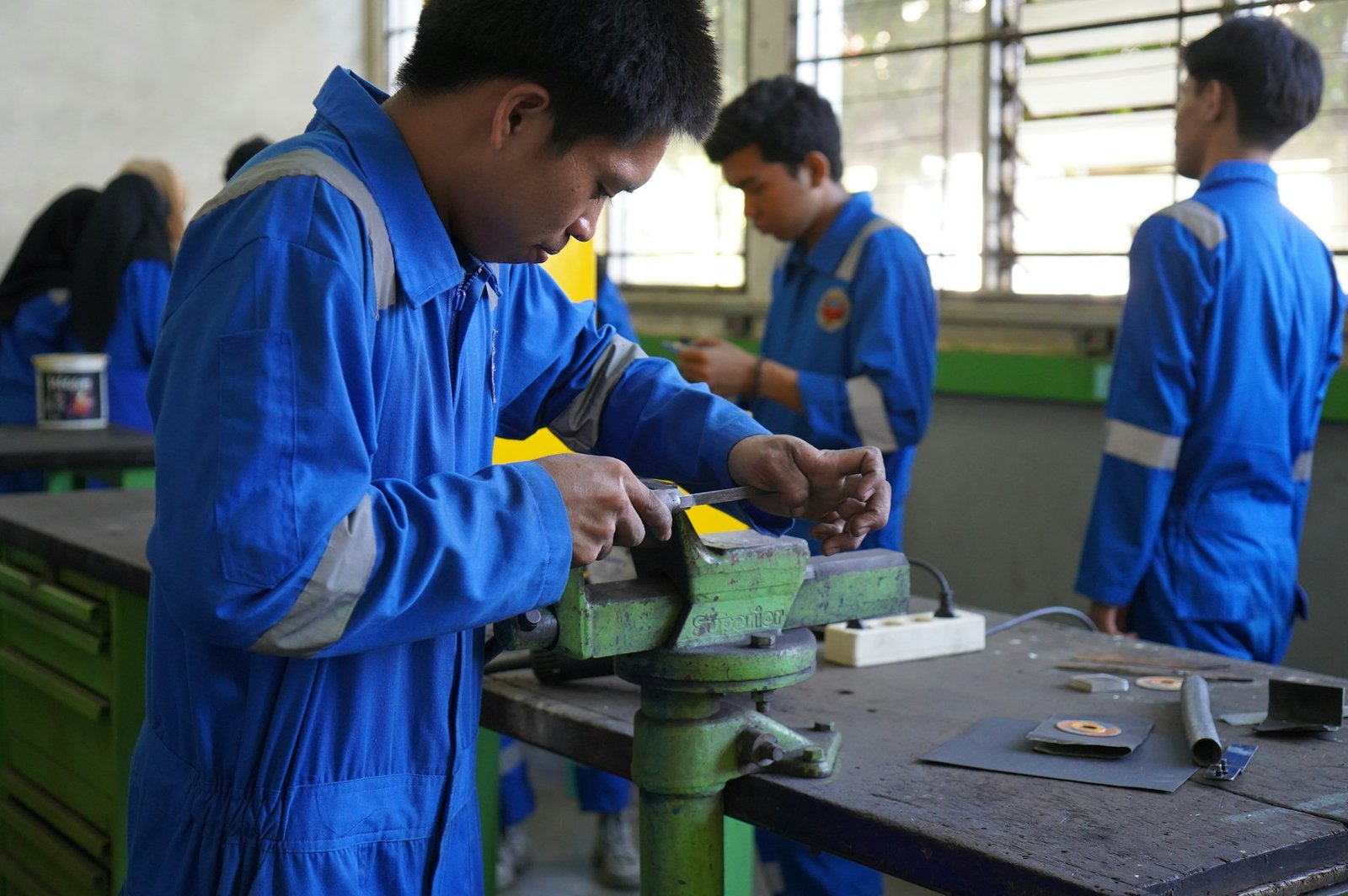 Trainees and their supervisor in a metal workshop