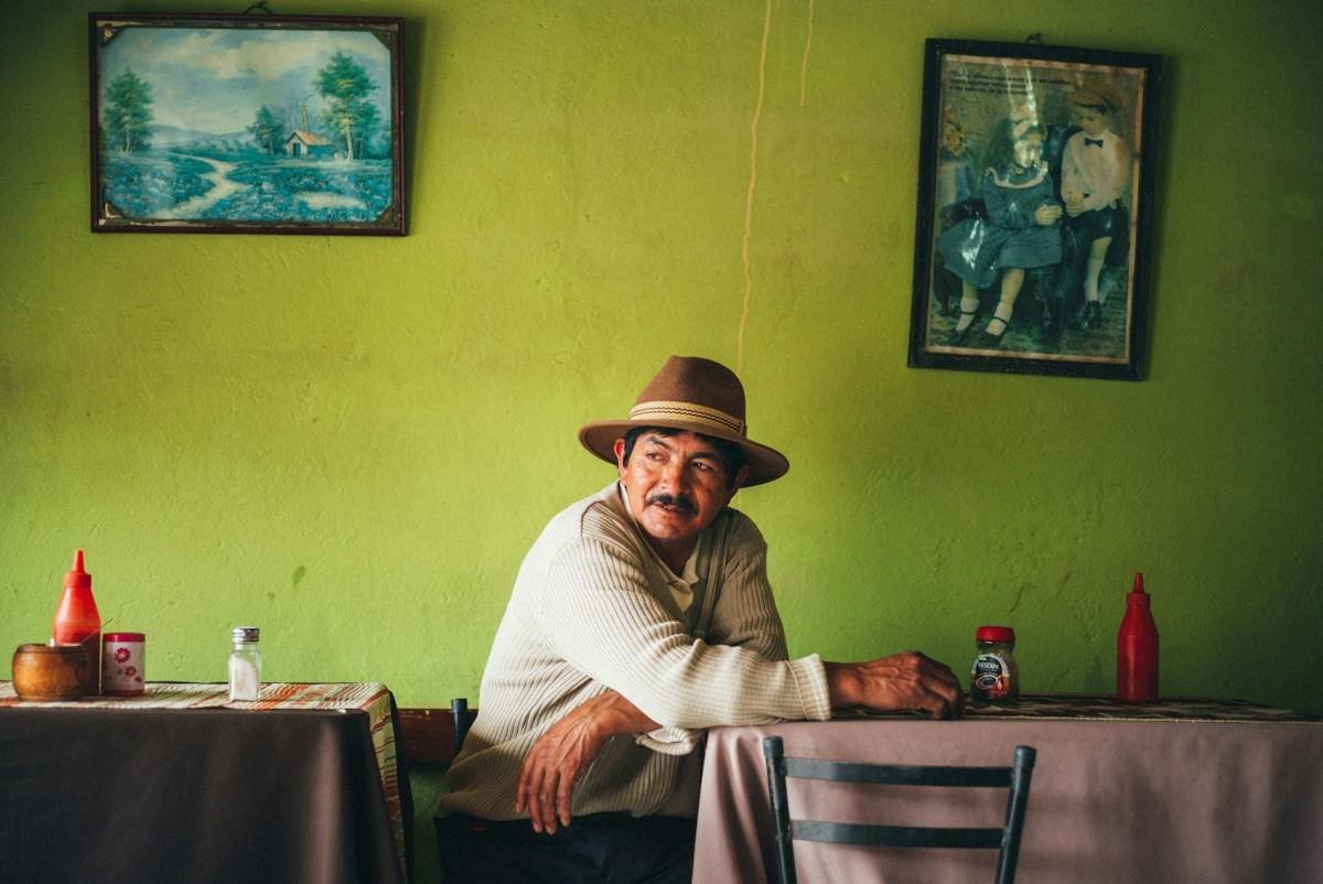 A smiling man in a hat sitting at a table