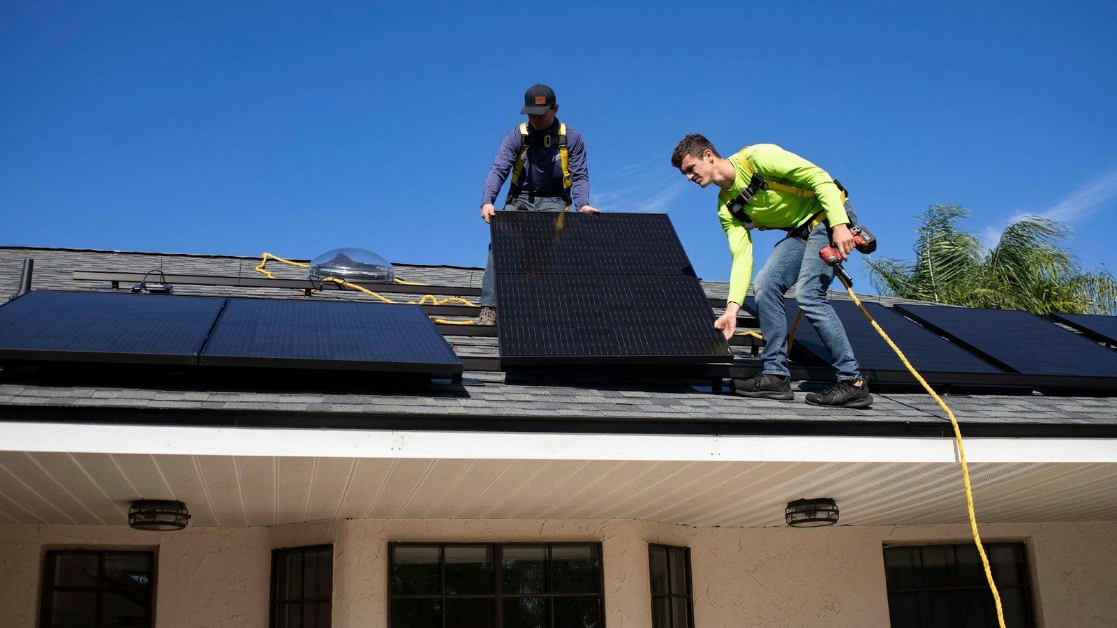 Solar installers fitting panels on a roof