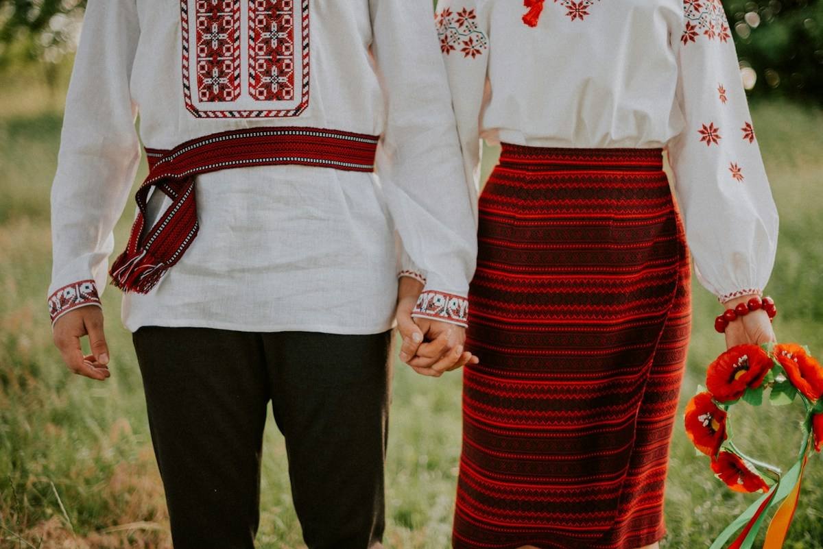A Ukrainian couple in embroidered shirts holding hands