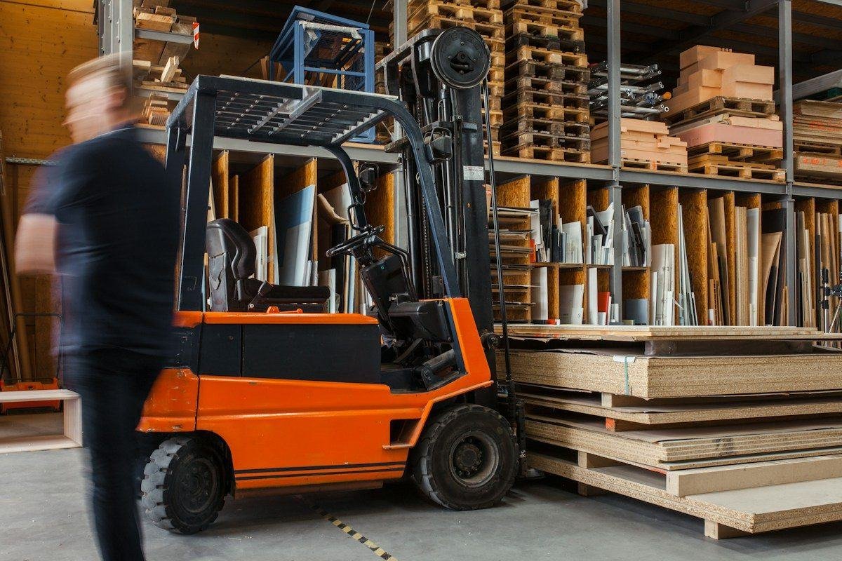 A forklift operator moving pallets in a warehouse